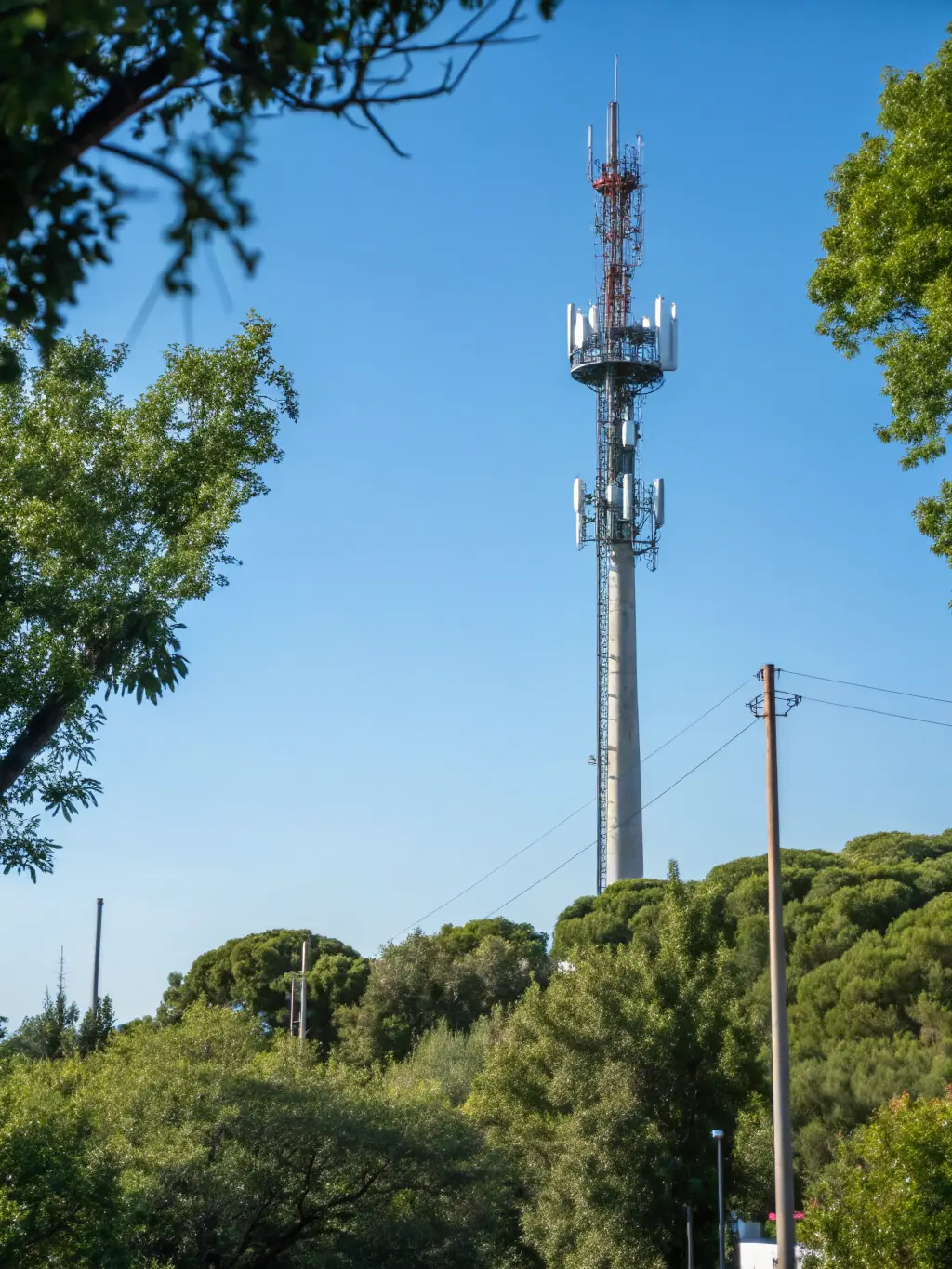 A wide shot of a telecommunications tower with RF equipment installed, emphasizing the application of Smartrfsolutions' technology in the telecommunications industry, under a clear blue sky.